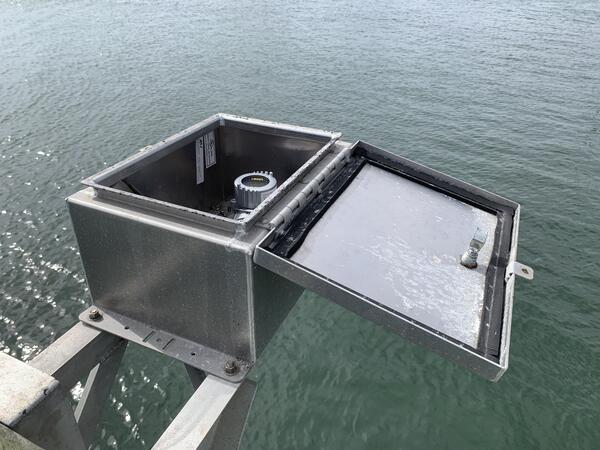 Looking into an open steel box suspended over the bay to see the radar electronics inside