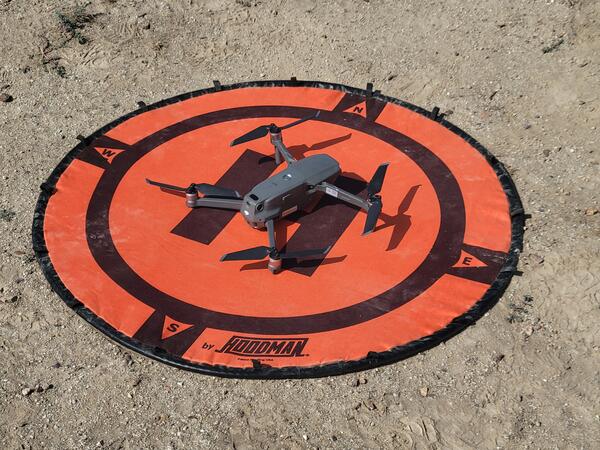 a drone on a bright orange circular landing pad 
