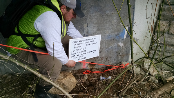 A hydrographer providing a written description of a flagged high-water mark using a white board.