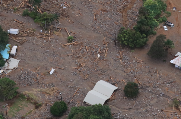 Upstream buried homes and trucks buried in mud and by large boulders and lots of wood