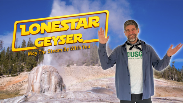 Many with arms raised standing in front of am erupting geyser with forest and blue sky in the background