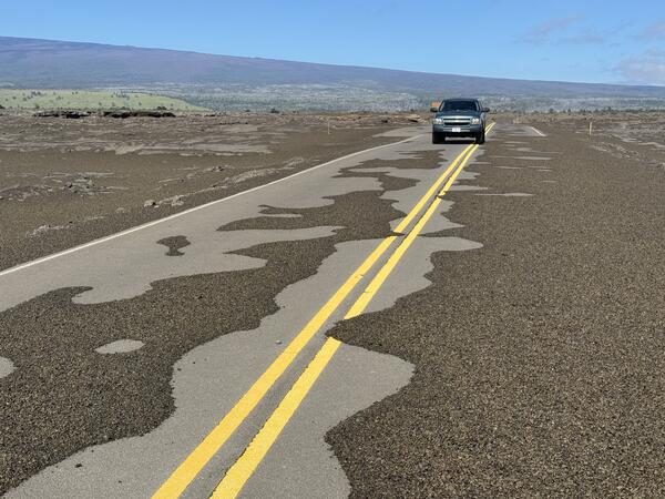 Color photograph of volcanic material deposited on road