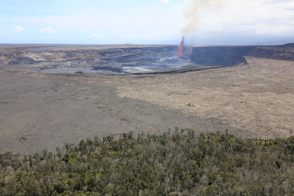 Color photograph of caldera with eruption within it