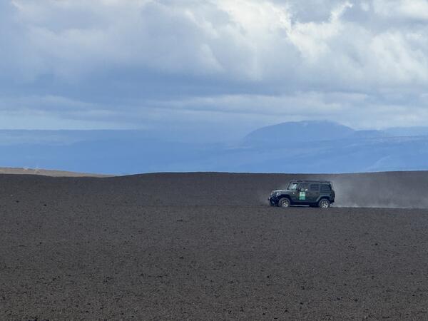 Color photograph of car driving on tephra deposit
