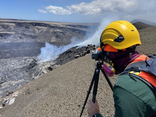 Color photograph of scientist on volcanic crater rim