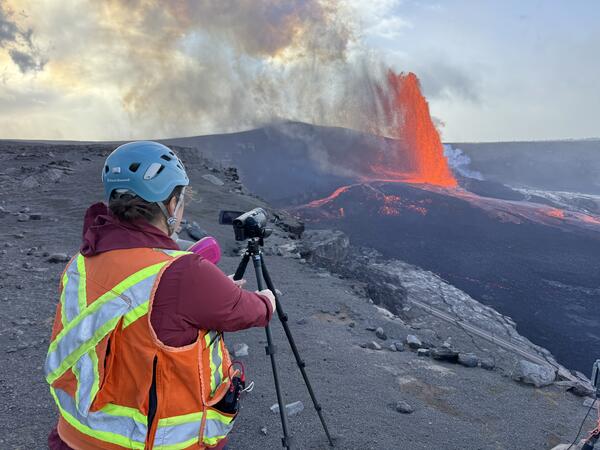 Color photograph of scientist monitoring volcanic eruption