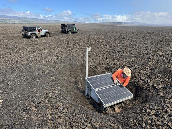 Color photograph of person fixing monitoring station