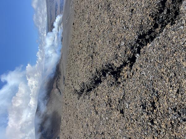 Color photograph of volcanic deposit with crack in the ground