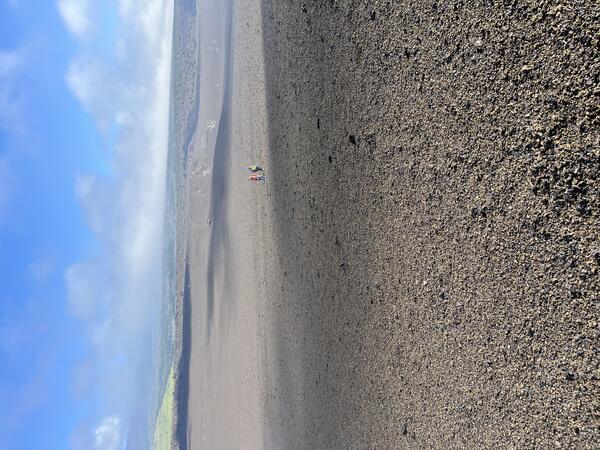 Color photograph of volcanic landscape with people in the background