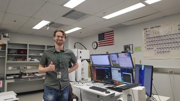 Nicholas E Powell gives a thumbs up while proudly showing off new lab equipment