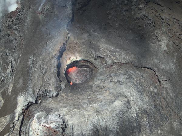 Color photo looking inside the north vent of the Halema‘uma‘u crater with lava visible in the vent. 