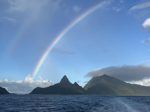 Color photo of a rainbow over the ocean.