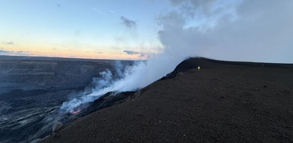 Color photo of the southwest side of Halemaʻumaʻu crater at the large tephra deposit that has grown since December 2024.