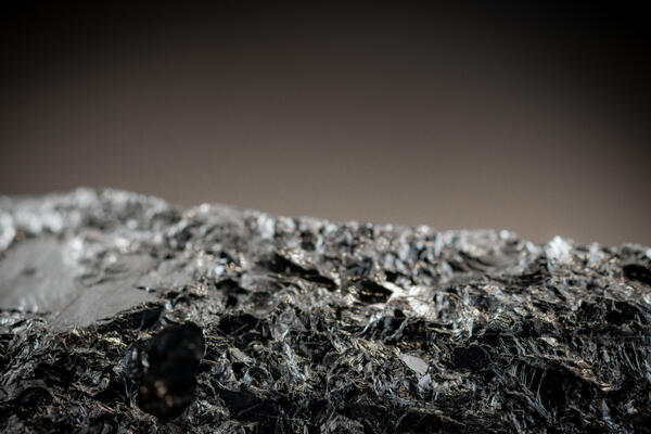 Macro image of silicon metal specimen showing detailed texture and metallic surface.