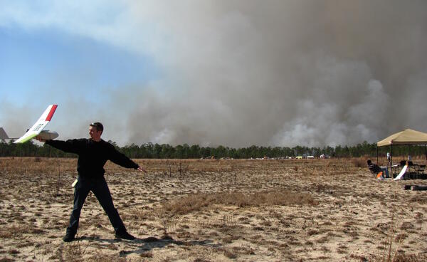 Remote pilot preparing to hand launch a fixed wing UAS during a prescribed wildfire burn in Florida