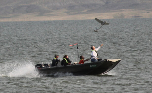 Fixed wing UAS being hand launched from a boat on the Missouri River