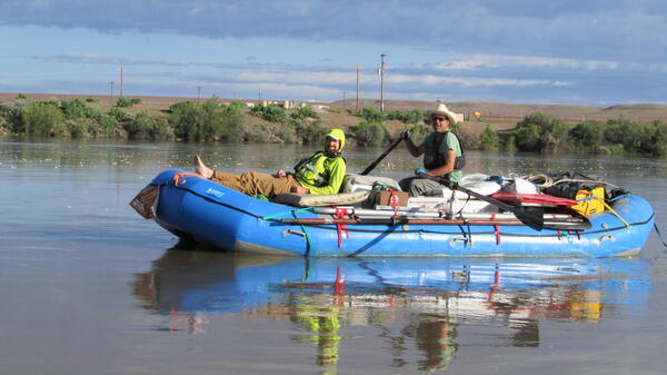 Two guys in raft smiling at camera.