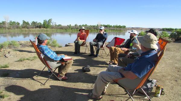 People seated in a circle talking.