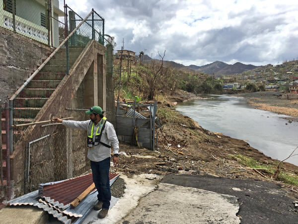 A USGS hydrologic technician examines a wall in Puerto Rico for a high-water mark after flooding from Hurricane Maria.
