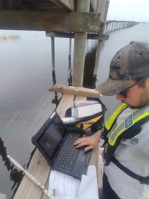 USGS hydrographer Brett Johnston works at a storm-tide sensor site
