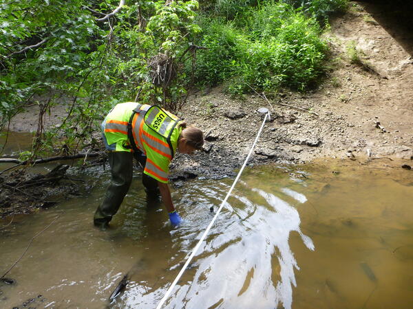 USGS Hydrologist Heather Krempa collects a stream sample at Little Fabious River, near Monticello, Missouri