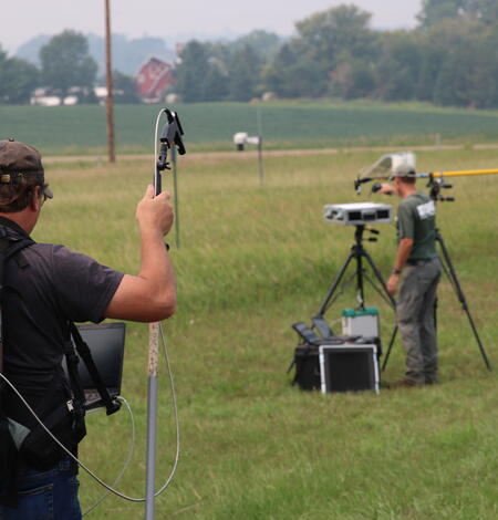 Engineers are photographed in the field monitoring calibration measurements supporting Landsat 
