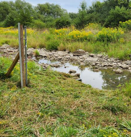 A USGS streamgage next to a dry riverbed.
