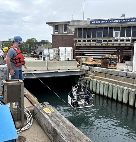 equipment being lowered into the water by people on a dock