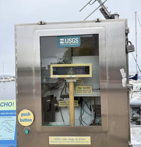 A USGS streamgage in a metal box with a clear door.