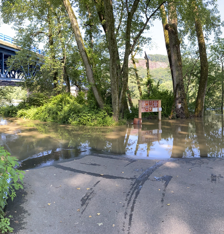 A river overflows into a parking lot.