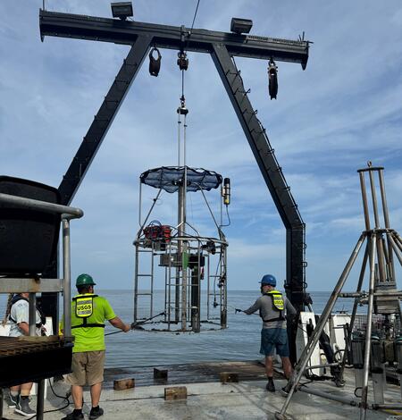 Three people on deck of ship working with mega multicorer