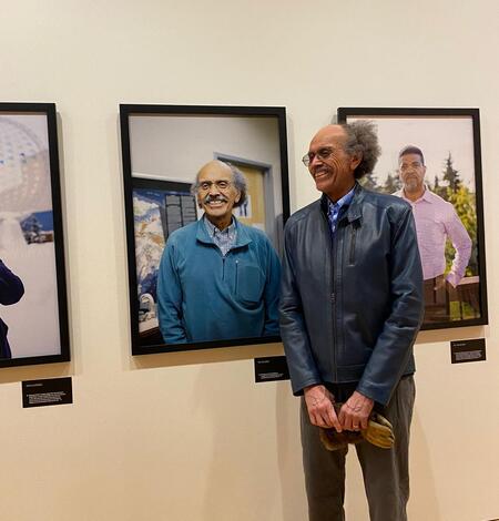 Ric Wilson stands next to a portrait of himself during a presentation of "Black in Alaska" in Anchorage. 