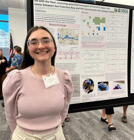 Physical Scientist, Amelia Ayers stands in front of her poster illustrating the transport of harmful algae in the Delta.