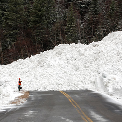 mountain road with huge pile of snow from avalanche piled on top