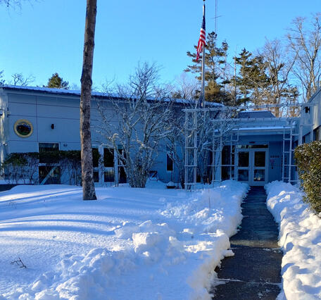 building with lots of snow on the ground and a shoveled path to the door