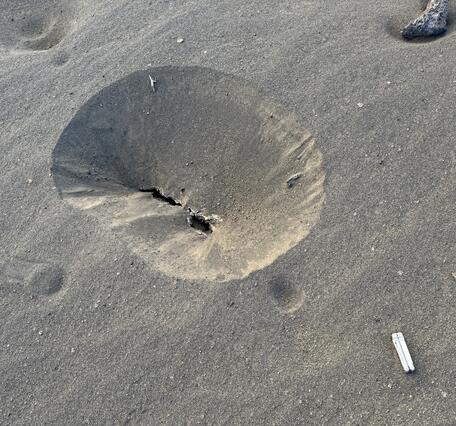 Color photograph of sinkhole deposit in a volcanic landscape