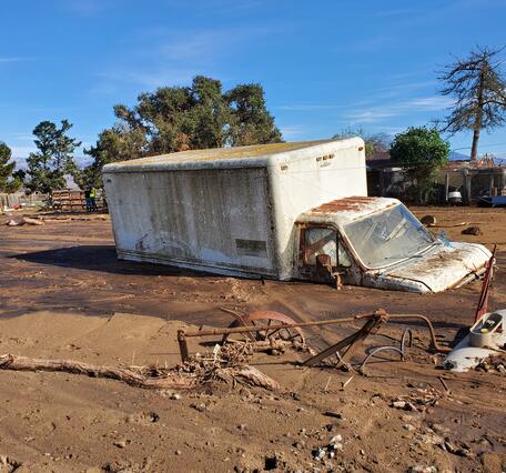large truck partially buried by mud