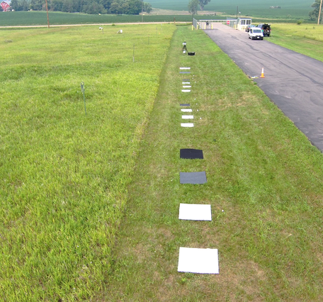 Square, colored reference targets spaced in the grass along roadside