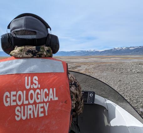  arid, open landscape with snowy mountains in the distance. 
