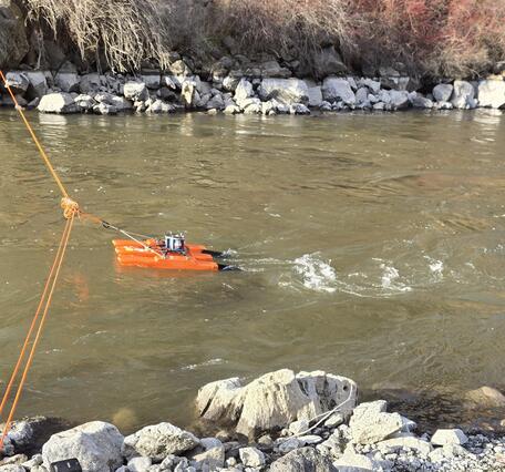 an orange trimaran boat on a tether