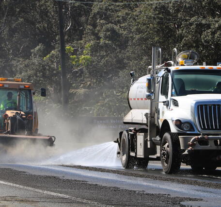Color photograph of road being cleaned of tephra