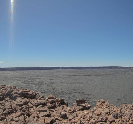 Color photograph showing a volcanic plume rising in the background of a volcanic caldera