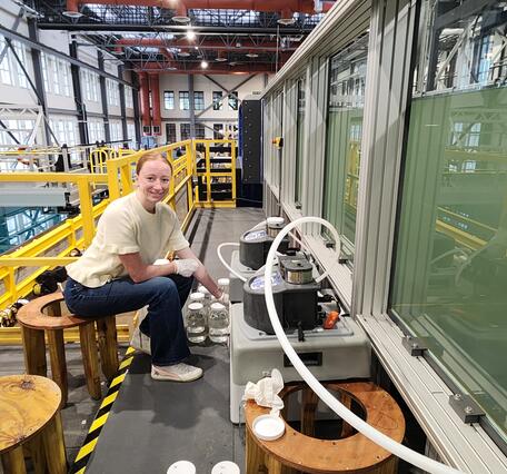 smiling person seated next to sampling equipment