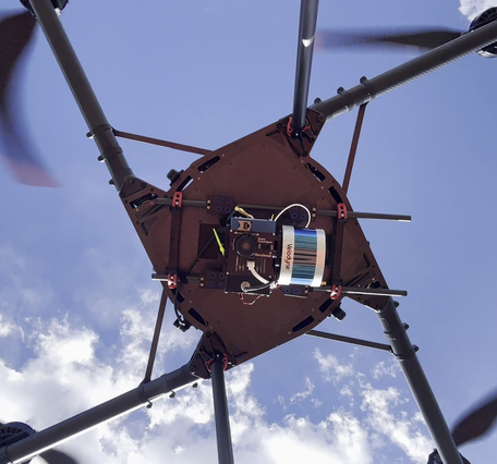 Underside view of flying drone with hyperspectral imaging payload with integrated lidar sensor