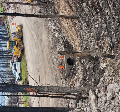 heavy equipment parked on road near watershed outlet