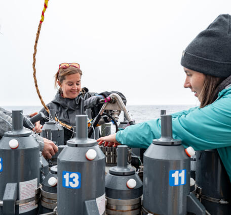 Three people prepare a CTD for deployment