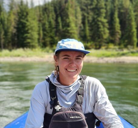 An image of Sarah Newcomb smiling in front of a river. 