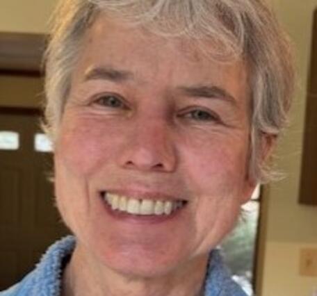 Woman with short blond hair smiling at camera 