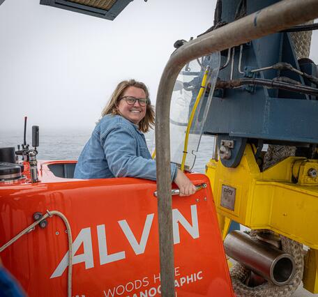 A person smiles while in the entrance to the submersible Alvin