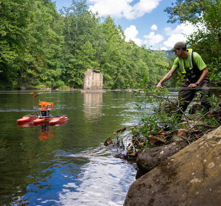 Eric Boyd pulls an Acoustic Doppler Current Profiler across a river.